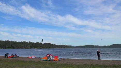 Kitesurfing-At-Floras-Lake-In-Oregon-On-A-Sunny-Summer-Day---panning-shot,-slow-motion