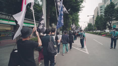 Policías-Escoltando-A-Personas-Que-Protestan-En-Las-Calles-De-Tokio---Solidaridad-Con-La-Protesta-De-Hong-Kong-En-Japón---Tiro-De-Mano,-Punto-De-Vista