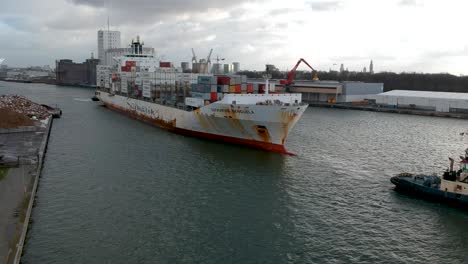 Tugboat-is-dragging-huge-container-ship-out-of-Antwerp-harbor