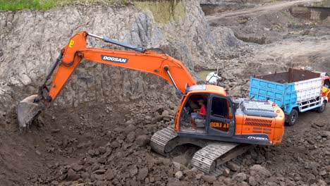 Excavadora-De-Cadenas-Pesadas-Cargando-Rocas-En-Un-Camión-Volquete