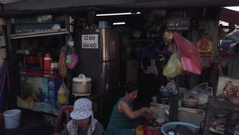 Vietnam,-Ho-chi-Minh-City,-a-panning-street-life-scene-in-an-urban-area-featuring-small-food-businesses-and-people-enjoying-family-life-outdoors-in-the-street