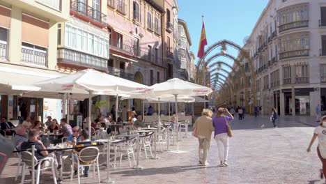 Gente-Con-Máscaras-Paseando-En-Un-Día-Soleado-En-Málaga,-España,-Con-La-Hermosa-Calle-Marques-De-Larios-Al-Fondo---Toma-Amplia