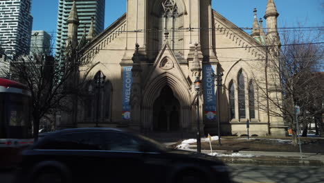 Gran-Angular-En-Un-Tranvía-Y-Un-Automóvil-Que-Pasa-A-Través-Del-Marco,-Con-Una-Lenta-Inclinación-Hasta-La-Iglesia-Catedral-De-La-Torre-De-San-James