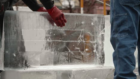 Escultor-De-Hielo-Deslizando-Un-Bloque-De-Hielo-En-Posición-Para-Tallar,-Cámara-Lenta