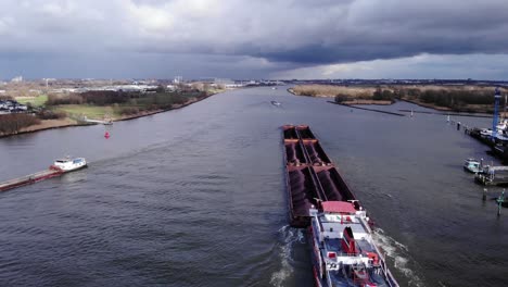 Sechs-Lastkähne-Mit-Schubschlepper-Am-Fluss-Oude-Maas-In-Der-Nähe-Von-Puttershoek-In-Den-Niederlanden-Mit-Bewölktem-Himmel