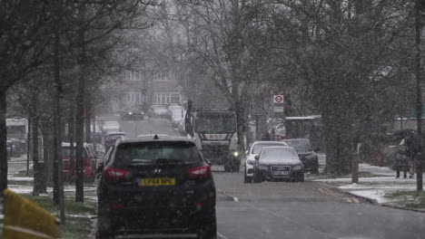 Coches-Y-Camiones-Saltando-Pasando-Por-Una-Carretera-Residencial-En-La-Nieve