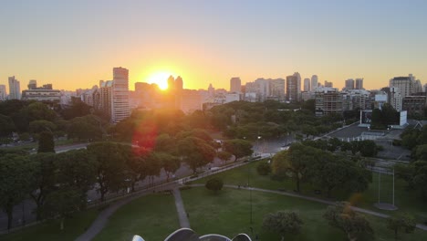 Jib-down-revealing-Floralis-Generica-steel-sculpture-with-Recoleta-buildings-in-background-at-sunset