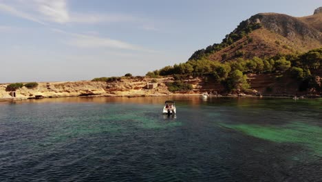 Low-aerial-approaches-boaters-in-beautiful-Platja-des-calo-in-Majorca