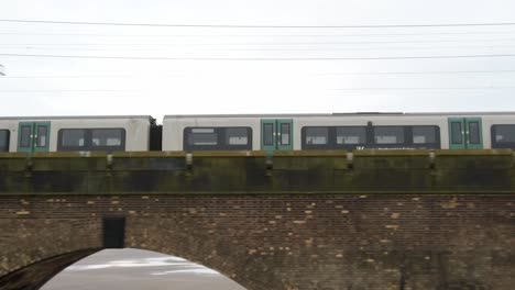 Public-train-crossing-Runcorn-bridge-old-castle-turret-building-tower-tracking-right-pan