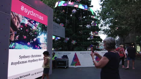 People-wall-around-outdoors-during-a-holiday-festival-with-deocrated-christmas-trees-and-holiday-shopping