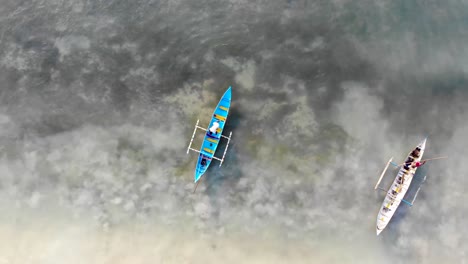 Local-fisherman-work-on-their-man-made-boats-over-shallow-coral-reef