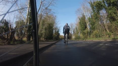 Ciclista-Siendo-Superado-Lentamente-Por-Otros-Ciclistas-En-La-Carretera-Del-Campo