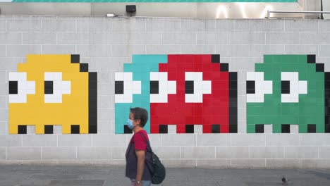 Se-Ve-A-La-Gente-Caminando-Junto-A-Un-Arte-De-Wall-Street-Que-Representa-El-Clásico-Juego-De-Arcade-Pac-Man-En-Hong-Kong.