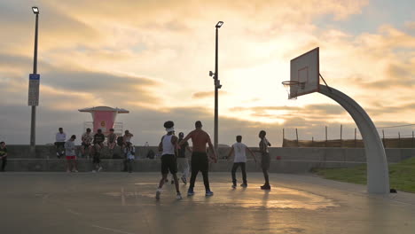 Hombres-Jugando-Baloncesto-En-Una-Cancha-De-Baloncesto-Al-Aire-Libre-En-Imperial-Beach,-California-Al-Atardecer