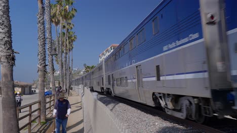 Tren-Pacific-Surfliner-Corriendo-Por-San-Clemente-Junto-A-Un-Chico-Paseando-A-Su-Perro