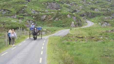 Mujeres-Turistas-Y-Carruajes-De-Caballos-Viajando-Por-La-Brecha-Del-Paso-De-Montaña-De-Dunloe-En-El-Condado-De-Kerry,-Irlanda