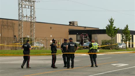 Policemen-Within-Yellow-Barrier-Tape-In-A-Vehicular-Accident-Area-In-Toronto,-Canada