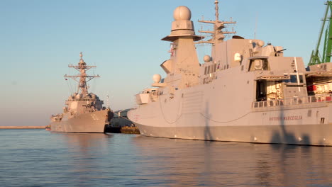 Panning-shot-of-military-ships-docking-at-harbor-of-Gdynia-during-sunset-in-Poland