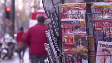 Hombre-Corriendo-Pasado-Revistas-En-Quiosco-En-El-Centro-De-Atenas,-Grecia