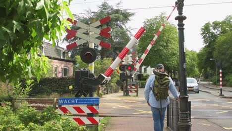 Railroad-barriers-on-a-railroad-crossing-opening-and-people-passing-through