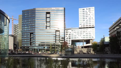 Zeitraffer-Am-Hauptbahnhof-Von-Utrecht-Mit-Menschen,-Die-Die-Große-Treppe,-Die-Zu-Den-Modernen-Gebäuden-Führt,-Auf--Und-Absteigen-Und-Dabei-Das-Sonnenlicht-Reflektieren,-Das-Auf-Die-Außenfassaden-Aus-Glas-Scheint