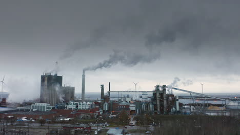 Toma-Aérea-Apocalíptica-épica-De-Una-Fábrica-Con-Chimeneas-Que-Arrojan-Humo