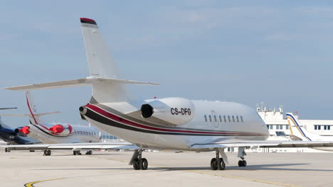 Jets-Privados-Alineados-Fuera-De-Un-Hangar,-Aeropuerto-De-Atenas,-Grecia,-Trípode