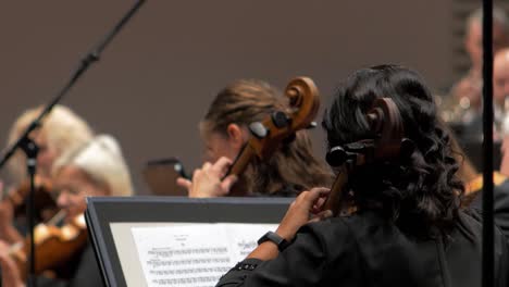 Fokus-Auf-Junge-Musikerinnen,-Die-Mit-Einem-Orchester-Cello-Spielen,-Saisoneröffnungskonzert-Des-Liepāja-Symphonieorchesters,-Konzertsaal-Great-Amber,-Mittlere-Aufnahme,-Rack-Fokus