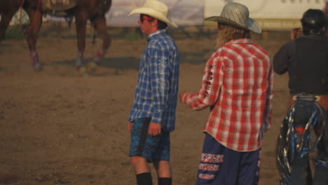 Cowboy-Läuft-Auf-Dem-Feld-Mit-Pferd-Im-Hintergrund