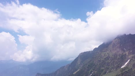 Aerial-low-angle-shot-of-clouds-cover-the-peak-of-a-mountain-in-Manali-India