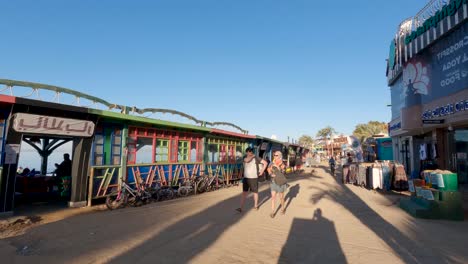 Paseo-Turístico,-Tiendas-Y-Restaurantes-A-Lo-Largo-De-La-Playa,-Dahab,-Egipto