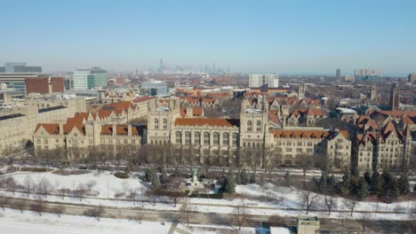 Vista-Aérea-Fija-Del-Campus-De-La-Universidad-De-Chicago-Con-El-Horizonte-De-Chicago-En-Segundo-Plano-En-El-Frío-Día-De-Invierno