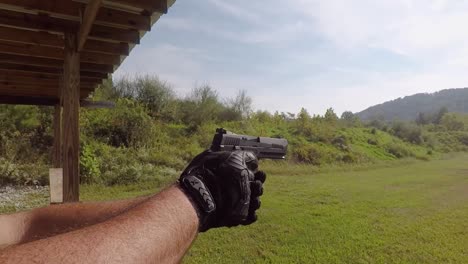 Close-Up-on-Hands-Holding-Pistol-Handgun-Pulling-Trigger-Empty-Shells-Flying