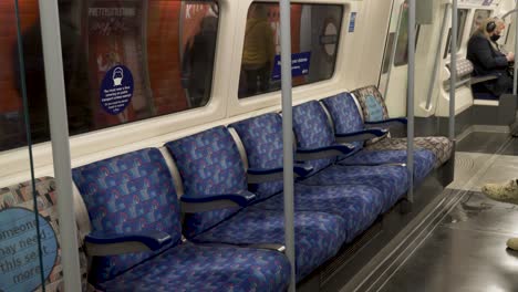 Fila-De-Asientos-Vacíos-En-El-Tren-De-La-Línea-Jubilee-En-El-Metro-De-Londres-Cuando-Sale-De-La-Plataforma-De-La-Estación