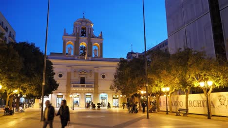 Parrocchia-Maria-Santissima-del-Monte-Carmelo-church-in-Taranto-at-night-with-people-walking-around