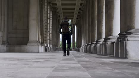 Turista-Masculino-Con-Mochila-Caminando-Por-La-Columnata-En-El-Royal-Navel-College-En-Greenwich