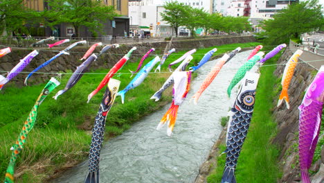 Matsumoto,-Nagano,-Alrededor-De-Mayo-De-2022:-Muchas-Coloridas-Serpentinas-En-Forma-De-Carpa-Volando-Sobre-El-Río,-Costumbre-Japonesa-En-Mayo,-En-Un-Lluvioso-Día-De-Primavera-En-El-Centro