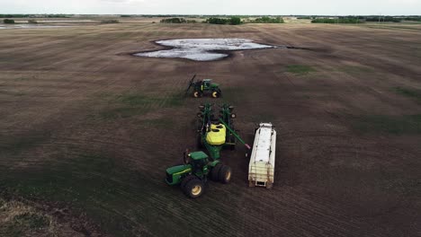 Toma-Aérea-De-Drones-De-Granjeros-Preparándose-Para-Sembrar-Un-Campo