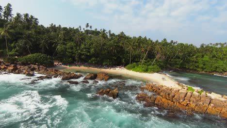 Aerial-FPV-drone-shot-of-sea-waves-crashing-in-the-rocks-in-the-beach