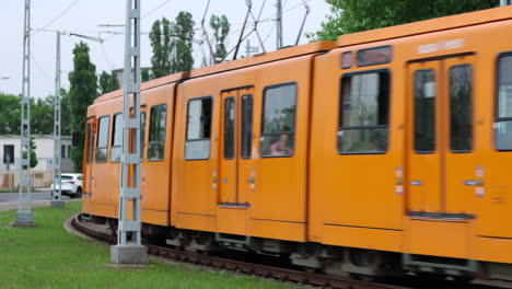 El-Tren-De-Cercanías-Eléctrico-Naranja-Gira-La-Curva-Hacia,-Pasa-La-Cámara