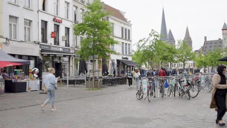 Crowd-of-people-walking-on-Vrijdagmarkt-on-a-cloudy-day-in-Ghent,-Belgium