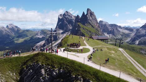 Seceda-En-Urtijei,-Tirol-Del-Sur,-Alpes-Italianos,-Dolomitas,-Italia---Vista-Aérea-De-Drones-De-La-Estatua-De-Jesús,-Turistas-Y-Pico-De-La-Montaña