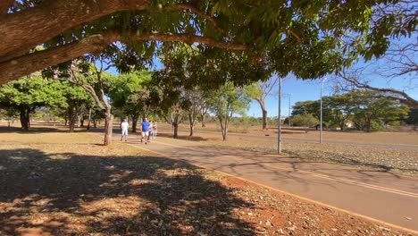 Tiro-Estable-Con-Un-Sendero-Ocupado-Al-Lado-De-Un-Carril-Bici-Igualmente-Ocupado-En-El-Parque-De-La-Ciudad-De-Brasilia-En-Un-Día-De-Verano