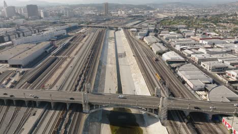 Volando-Sobre-El-Puente-De-La-Sexta-Calle,-También-Conocido-Como-Cinta-De-Luz,-En-El-área-De-Boyle-Heights-Del-Centro-De-Los-ángeles,-Drone-Sobre-Carreteras-Y-Vías-De-Tren