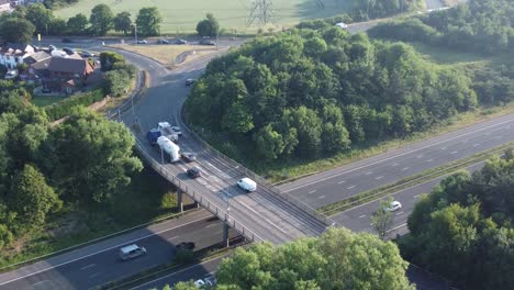 Aerial-zoom-out-view-lush-countryside-farmland-woodland-rural-M62-motorway,-Rainhill,-England