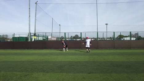 Two-Male-Friends-Doing-Stretches-Before-Football-Game-At-Goals-On-17-April-2022