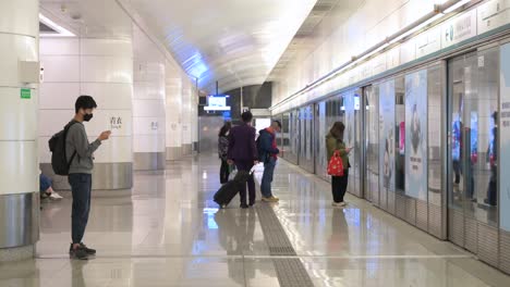 Chinese-commuters-wait-for-an-airport-train-to-arrive-at-an-underground-station-in-Hong-Kong