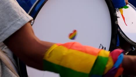 Persona-Tocando-Un-Tambor-En-Una-Banda-De-Música-Durante-El-Orgullo-2022-Con-Un-Corazón-De-Arco-Iris-En-Dili,-Timor-Leste,-Sudeste-De-Asia,-Cierre-De-Tambor,-Símbolo-De-Corazón-Y-Arco-Iris