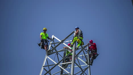 Tiro-De-Lapso-De-Tiempo-De-Trabajadores-De-La-Construcción-Industrial-Construir-Poste-De-Electricidad-Durante-El-Día-Soleado-Contra-El-Cielo-Azul