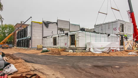 Shot-of-heavy-trucks-carrying-container-shaped-houses-been-lifted-and-placed-for-bulding-house-in-throughoout-the-day-and-night-in-timelapse